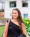 Woman in Black Sleeveless Top Standing Near Yellow Flowers