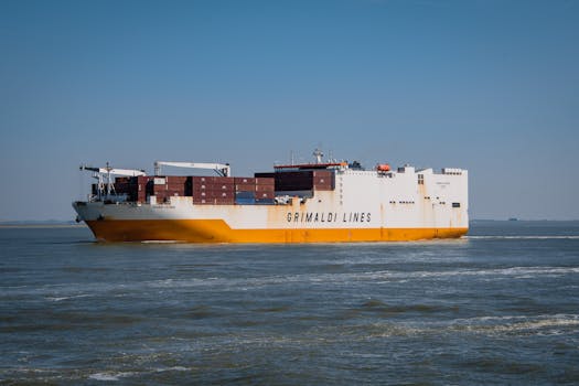 A Grimaldi Lines container ship navigating through the open ocean under a clear blue sky.