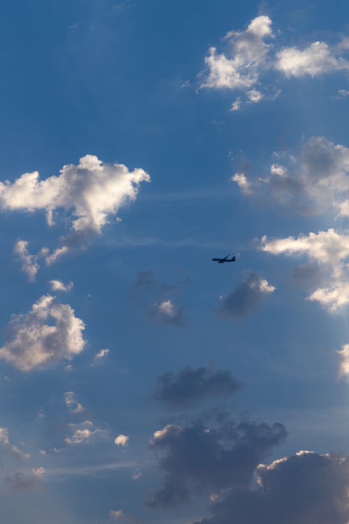 Free Airplane Flying Under Blue Sky and White Clouds Stock Photo