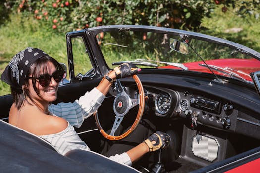 Smiling woman driving a vintage convertible in sunny Saxon, Switzerland.