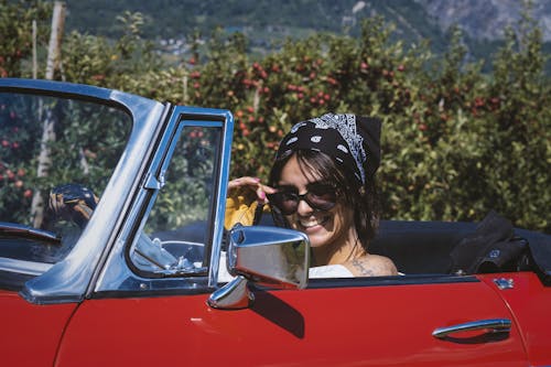 Free Beautiful Woman with Bandana on a Red Classic Car Stock Photo