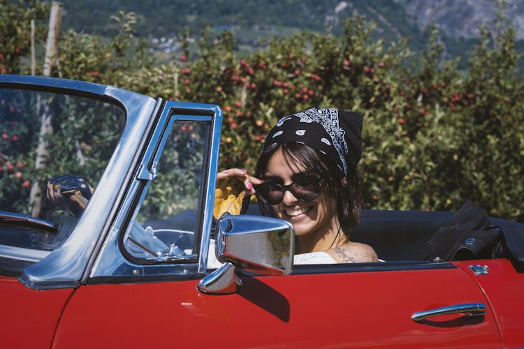 Beautiful Woman With Bandana On A Red Classic Car