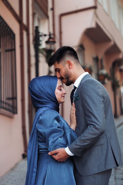 Free Charming couple in formal attire, sharing a tender moment on a city street. Stock Photo