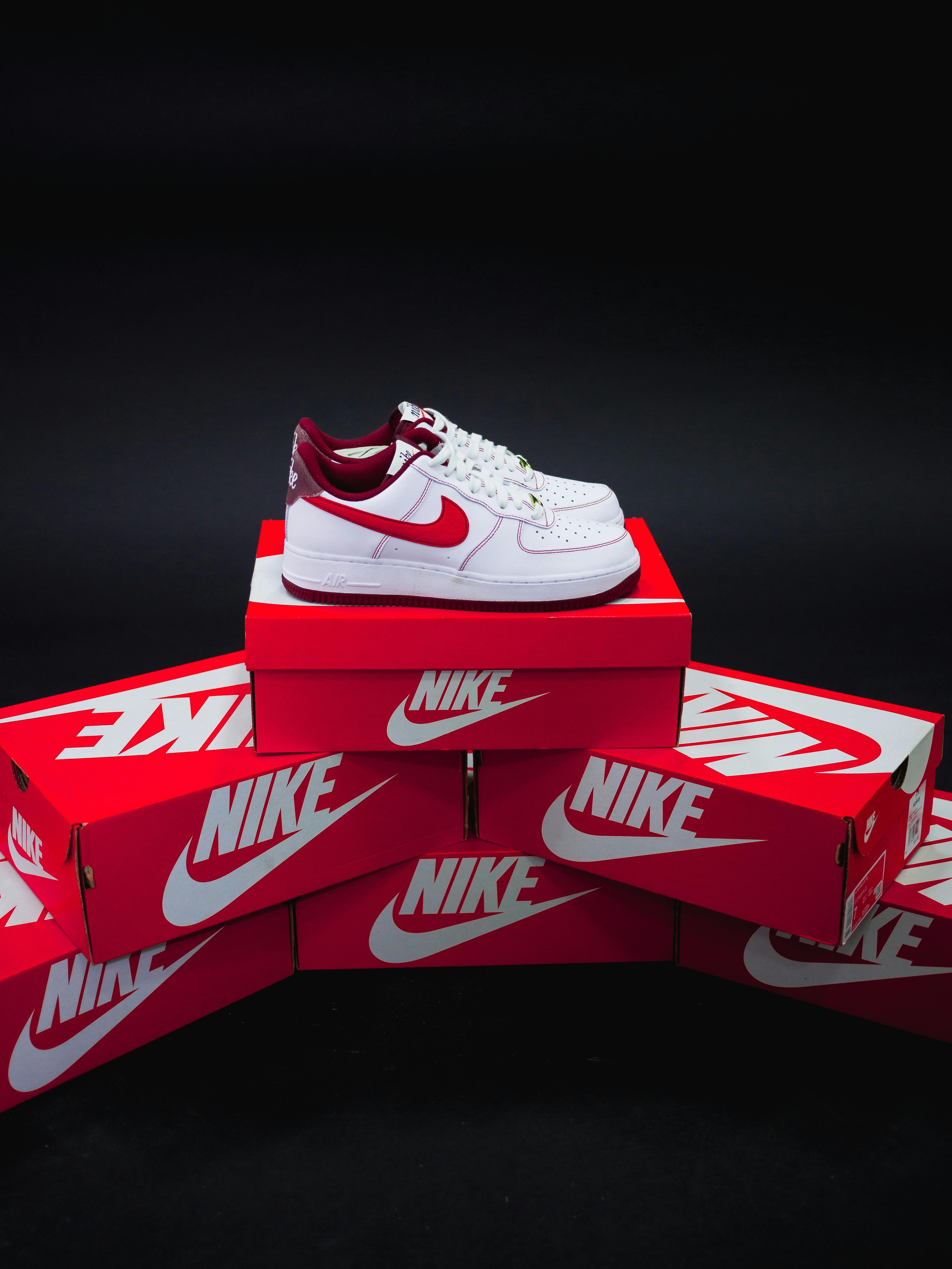 a pair of nike sneakers on a stack of shoeboxes