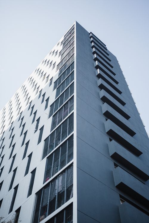 Free Low-angle view of a sleek modern high-rise building against a clear sky. Stock Photo