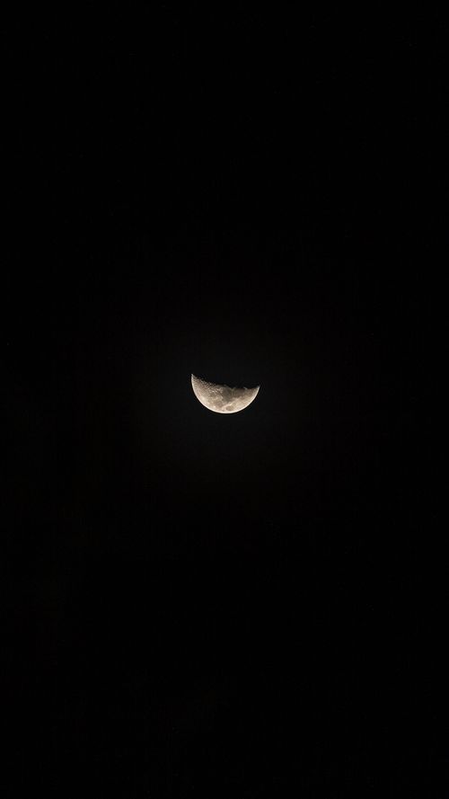 Free Captivating half moon with a glowing aura surrounded by a starry dark sky. Stock Photo