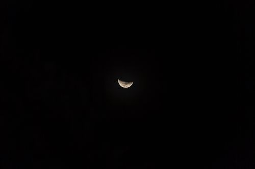 Free A serene photograph showcasing a half moon amidst a vast starry night sky. Stock Photo