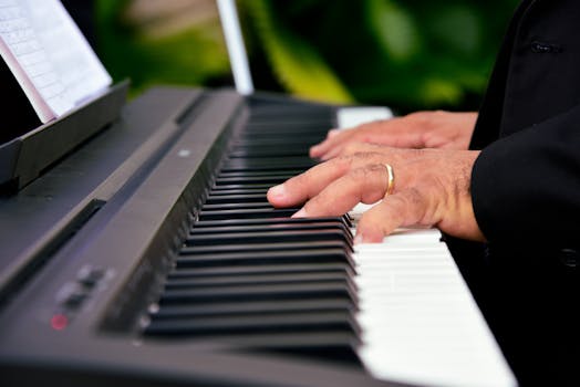 Hands playing a digital piano keyboard, capturing the essence of musical creativity.