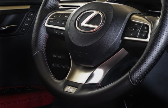 Close-up of a Lexus steering wheel showcasing luxury details and control buttons.