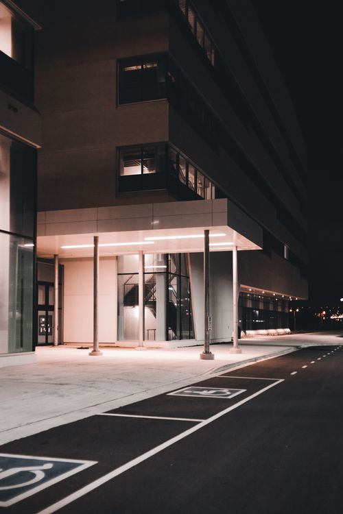 Free Illuminated modern building exterior at night with empty street. Stock Photo
