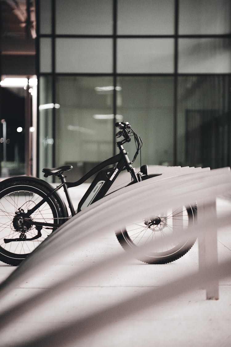 Photo Of A Black Bicycle Parked On A Bike Rack