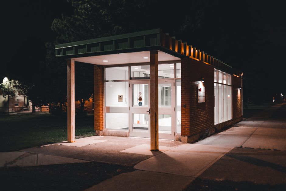 An illuminated building entrance with modern design captured at night.