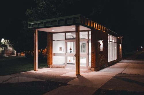 Free An illuminated building entrance with modern design captured at night. Stock Photo