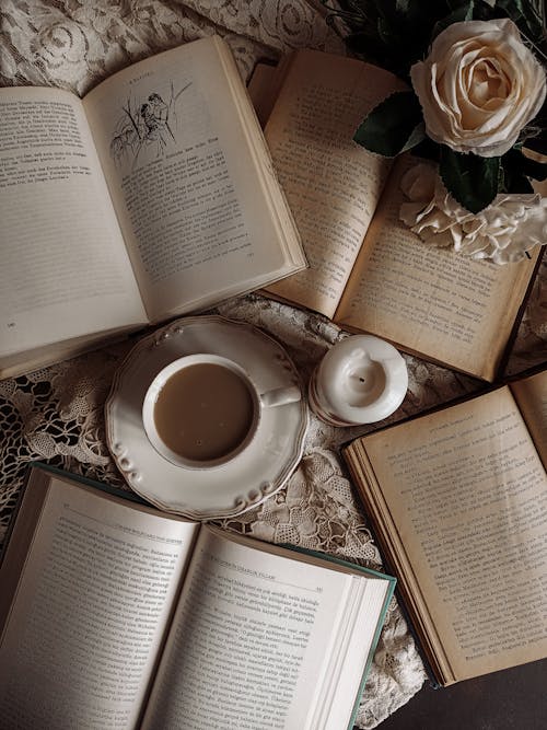 A Cup of Coffee and Candle Surrounded with Books 