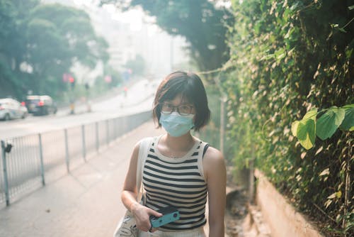 Free Woman Wearing Face Mask Standing on Sidewalk Stock Photo