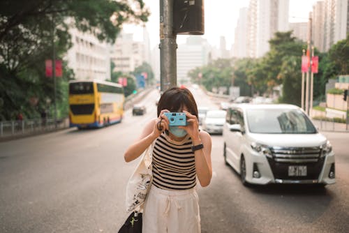A Person Standing in the Middle of the Street Taking Picture