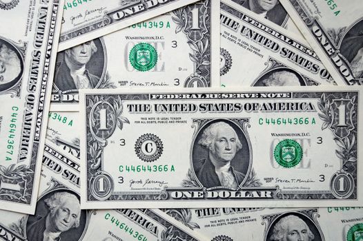 Detailed close-up of multiple one dollar bills showcasing U.S. currency design.