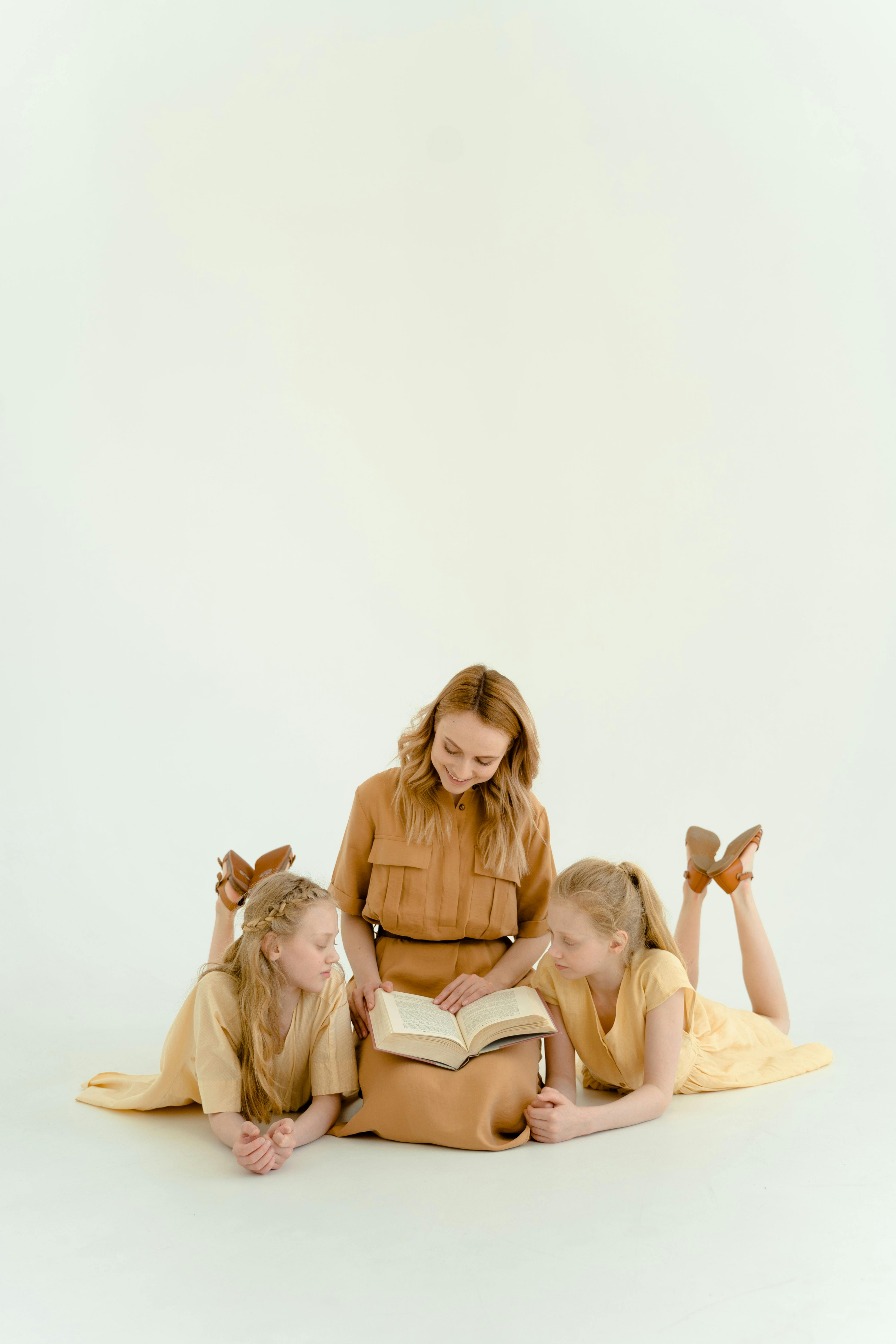 a mother reading a book to her daughters