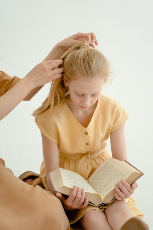 Woman in Brown Button Up Shirt Holding Book