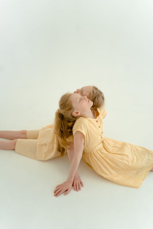 Woman in Yellow Dress Lying on White Floor