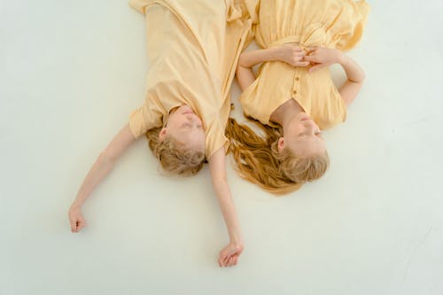 Woman in Yellow Dress Lying on White Floor