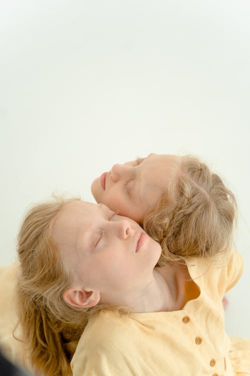 2 Children Lying on White Textile