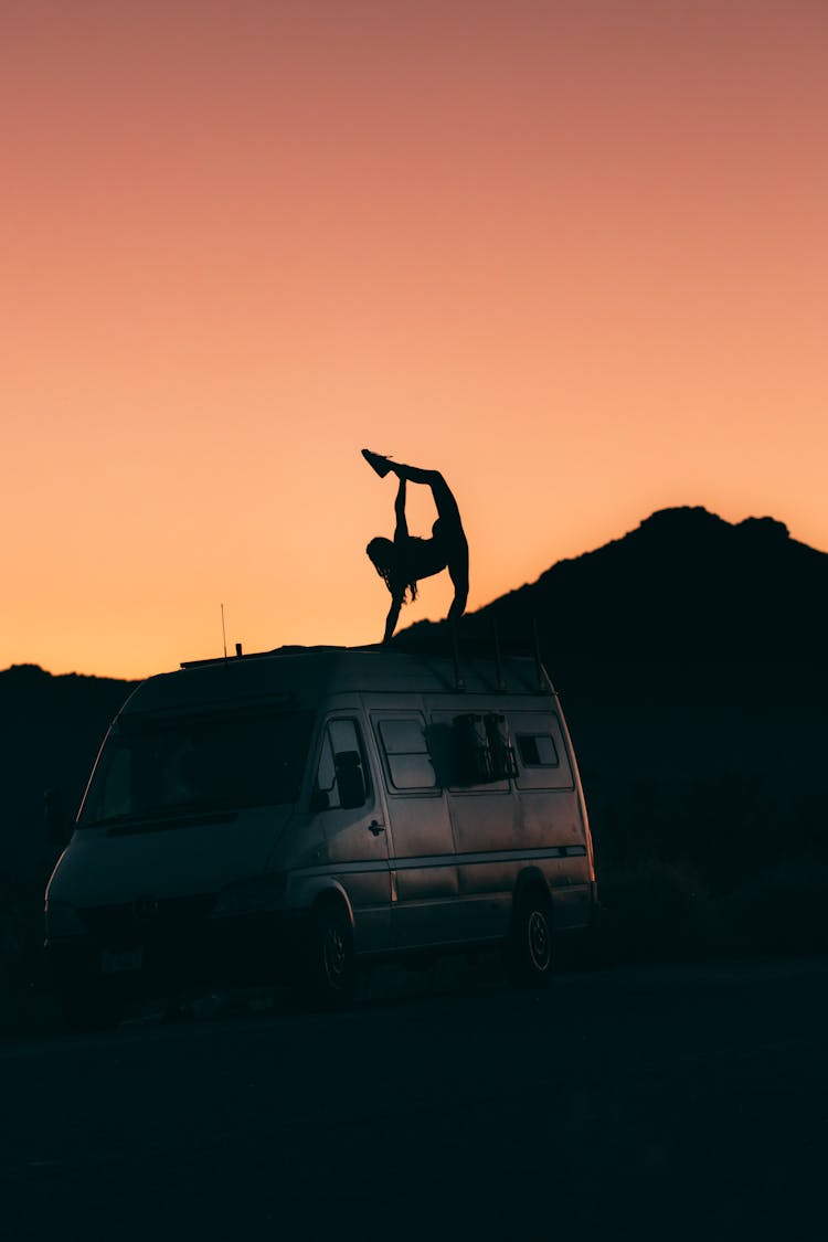 Silhouette Of Flexible Person On Top Of A Van