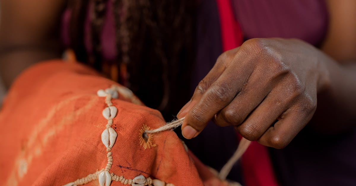 A Person Sewing in Shells on a Textile · Free Stock Photo