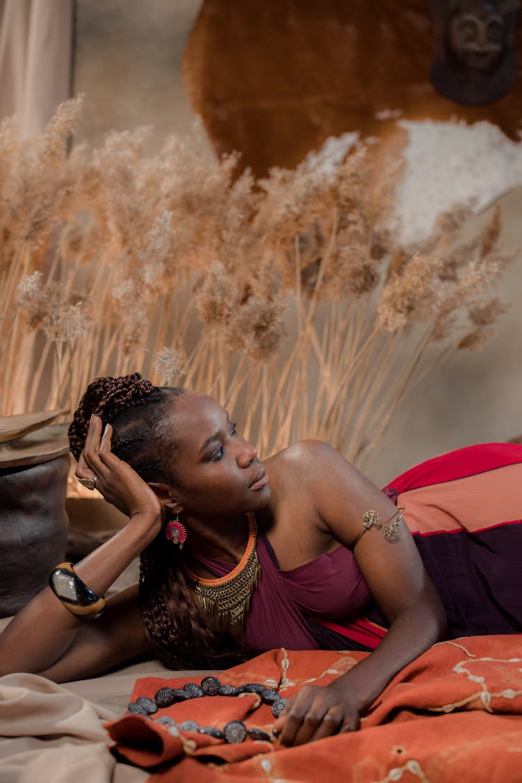 Woman In Purple Top Lying On Textiles