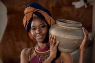 Woman Wearing Head Wrap Holding Gray Clay Pot