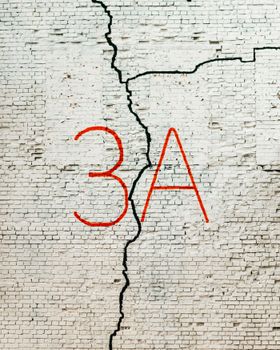 Close-up of a white brick wall with red graffiti '3A' and visible crack.