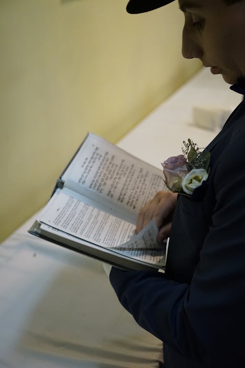 Person in Black Suit Reading a Book 