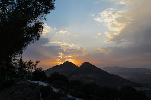 Silhouette of Mountains and Trees During Sunset