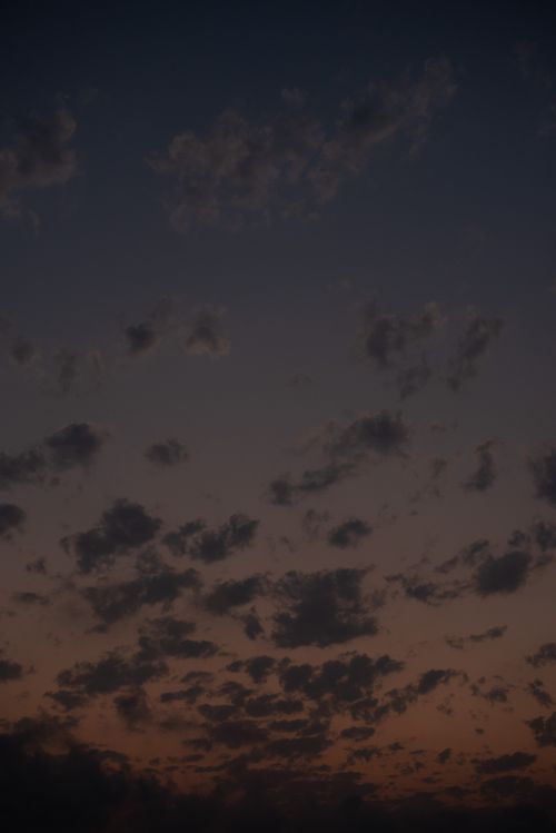 Free A tranquil evening sky with scattered clouds illuminated by soft twilight hues. Perfect for serene landscape backgrounds. Stock Photo