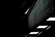 一张室内抽象照片，光线昏暗，可见几何形状的天花板和纹理丰富的墙壁