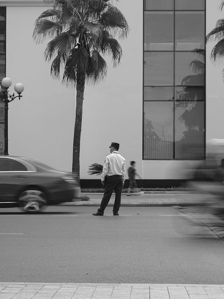 A Traffic Aide Standing On The Street Near A Vehicle