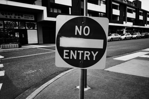 Free Monochrome urban scene featuring a prominent no entry sign on an empty street. Stock Photo