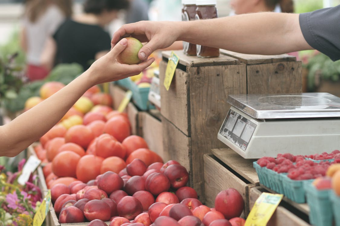 intercambio de fruta por dinero en un mercado