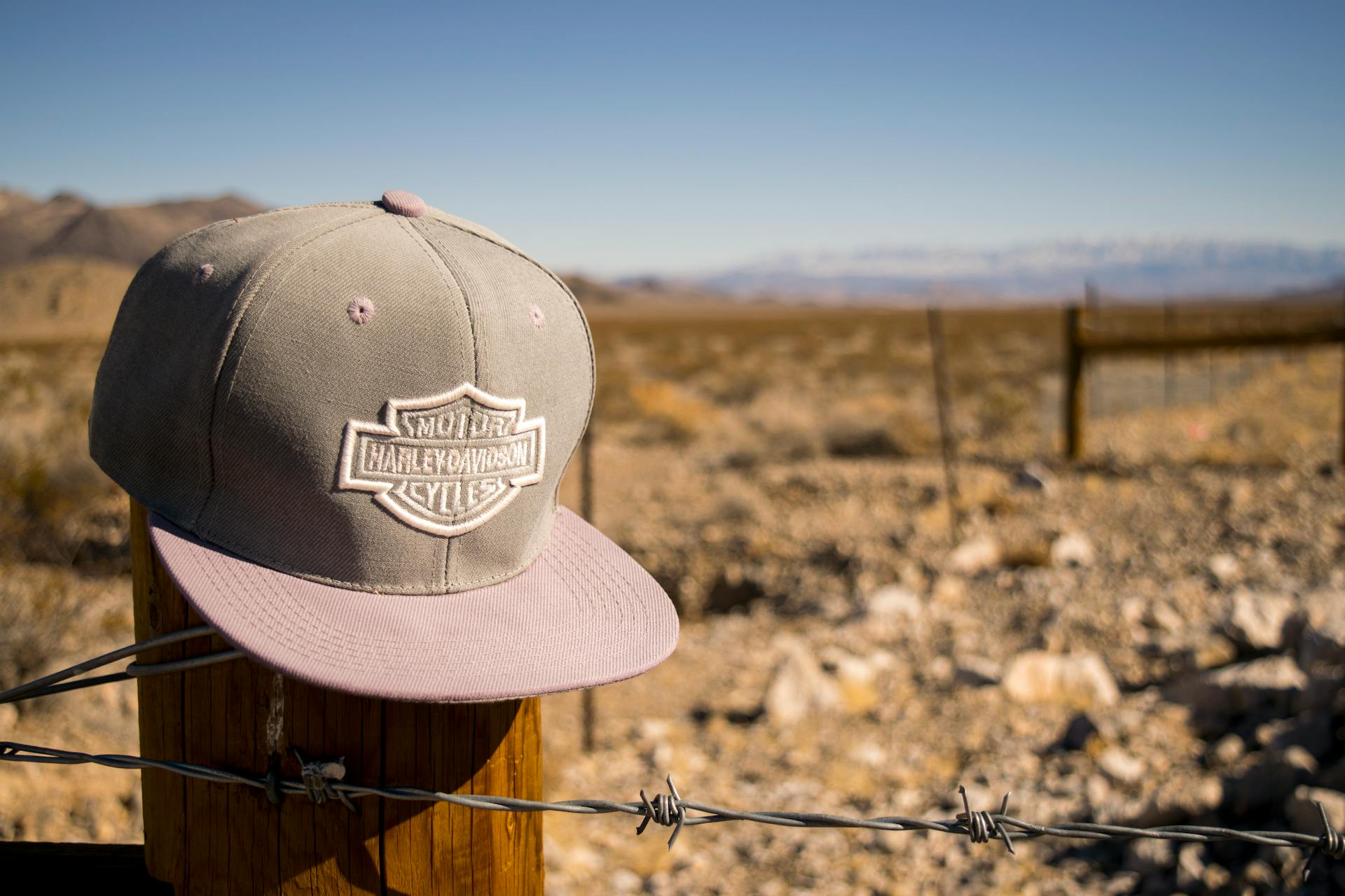 Gray Harley-davidson Motorcycles Flat-brimmed Cap Hanged on Brown Wooden Fence With Gray Barb Wires