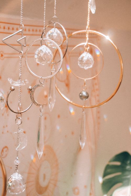 Free Close-up of hanging crystal ornaments with astrology symbols in soft light. Stock Photo