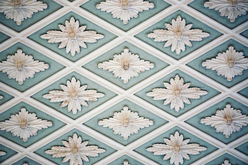 A White Floral Decoration on a Blue Base Wall