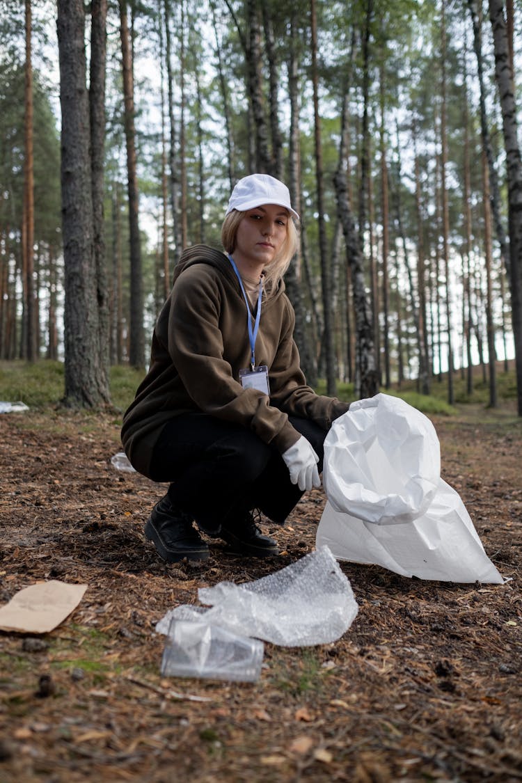 A Cleanup Volunteer Picking Up Recyclables From The Ground