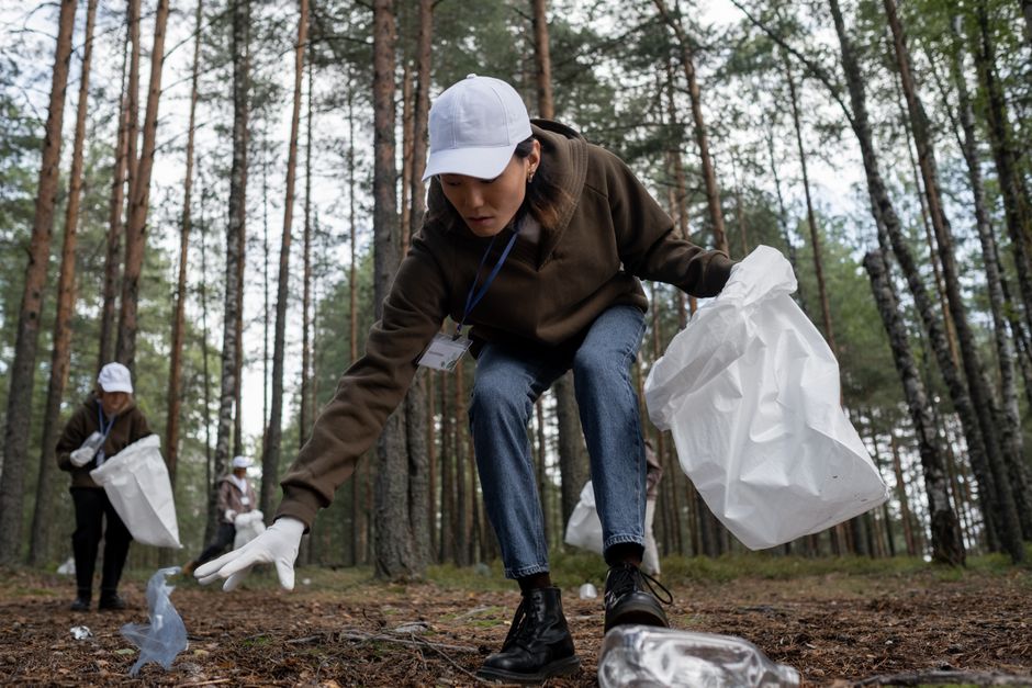 Volunteers participate in a forest clean-up, promoting environmental protection and community care.