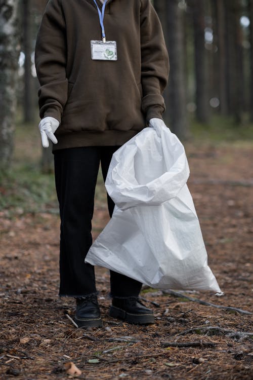 A Person in Brown Sweater Holding a Trash Bag