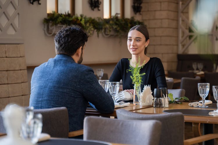 Man And Woman Sitting In A Restaurant 