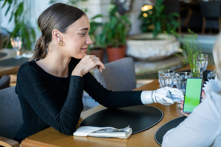 Woman Wearing Black Long Sleeves Reaching For The Phone