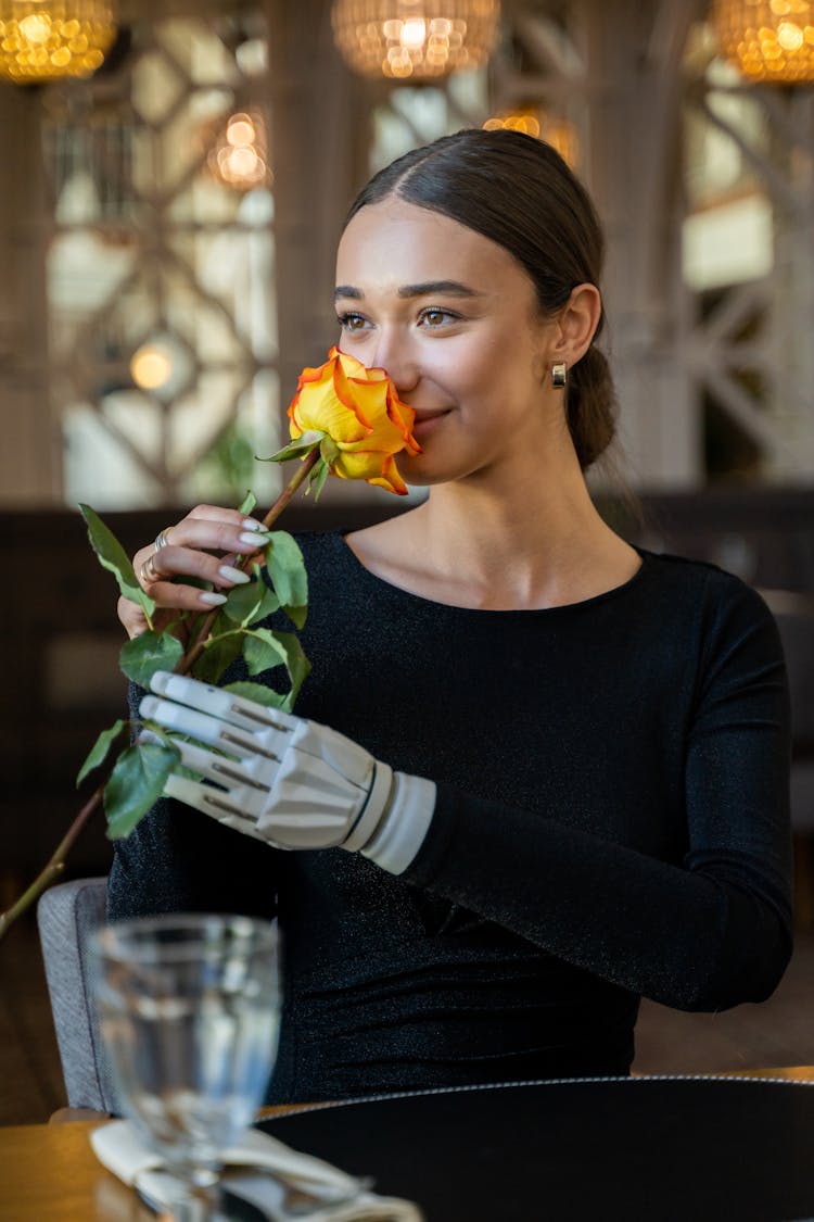 A Woman With Robotic Arm Holding A Rose