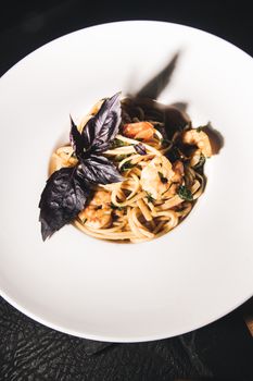 Gourmet shrimp pasta topped with fresh basil, perfect for food photography or culinary inspiration.