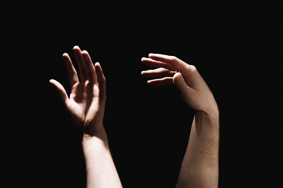 Two hands holding a glowing, starry constellation map representing love and compatibility between two horoscope signs