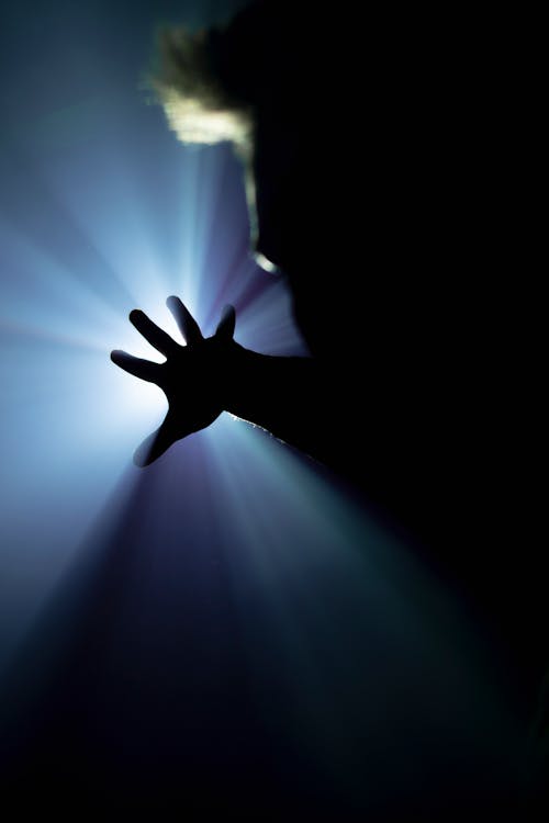 Silhouette of Person Covering Light on Hand 